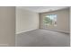 Bedroom features neutral walls, carpet, and window with view of the backyard at 7524 E Leland Cir, Mesa, AZ 85207
