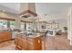 Open-concept kitchen with island cooktop, granite counters, breakfast bar, and seamless access to the living areas at 7524 E Leland Cir, Mesa, AZ 85207