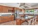 Gourmet kitchen features wood cabinets, stainless appliances, granite countertops, and center island cooktop at 7524 E Leland Cir, Mesa, AZ 85207