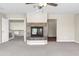 Cozy living room showcasing a fireplace, adjacent rooms, and neutral carpet at 7524 E Leland Cir, Mesa, AZ 85207