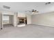 Spacious living room featuring a fireplace, neutral carpet, and a ceiling fan at 7524 E Leland Cir, Mesa, AZ 85207