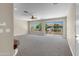 Bright living room with large windows, ceiling fan, and sliding glass doors leading to a balcony at 7524 E Leland Cir, Mesa, AZ 85207