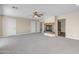 Large living room showcasing a fireplace, multiple doors, and neutral carpet at 7524 E Leland Cir, Mesa, AZ 85207