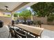 Covered patio with dining and lounging areas surrounded by lush landscaping at 7673 E Sands Dr, Scottsdale, AZ 85255