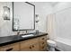 Charming bathroom features a framed mirror, black countertop, and a soaking tub at 7673 E Sands Dr, Scottsdale, AZ 85255
