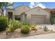 Beautiful desert landscaping complements the facade of this single-story home with a two-car garage at 7673 E Sands Dr, Scottsdale, AZ 85255