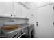Well-organized laundry room with Whirlpool machines and ample storage cabinets at 7673 E Sands Dr, Scottsdale, AZ 85255