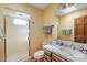 Cozy bathroom featuring a tiled shower, single sink vanity, and neutral color palette at 8210 E Del Cadena Dr, Scottsdale, AZ 85258