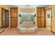 Bright bathroom with a tiled soaking tub, a walk-in shower, and built-in wooden storage cabinets at 8210 E Del Cadena Dr, Scottsdale, AZ 85258