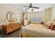Bedroom features a floral bedspread, wooden dresser, and a window seat with plantation shutters at 8210 E Del Cadena Dr, Scottsdale, AZ 85258