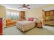 Bedroom with a colorful quilt, a ceiling fan, a window seat, and built-in bookshelves at 8210 E Del Cadena Dr, Scottsdale, AZ 85258