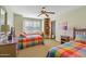 Inviting bedroom with two beds, a window seat, built-in shelves, and colorful bedding at 8210 E Del Cadena Dr, Scottsdale, AZ 85258