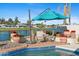 Sparkling pool area with shaded seating, lush landscaping, and serene lake views at 8210 E Del Cadena Dr, Scottsdale, AZ 85258
