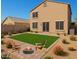 Inviting backyard featuring a fire pit, synthetic lawn, and low-maintenance desert landscaping at 8879 W Cameron Dr, Peoria, AZ 85345