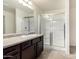 A bathroom featuring dark cabinets and a shower with a glass enclosure at 8879 W Cameron Dr, Peoria, AZ 85345
