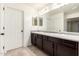 Bathroom featuring double sinks with dark wood cabinets, and tiled floors at 8879 W Cameron Dr, Peoria, AZ 85345