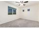 Bedroom featuring carpet, a ceiling fan, and a window with a view of greenery at 8879 W Cameron Dr, Peoria, AZ 85345