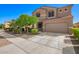 Two-story home featuring tan stucco, a two-car garage, and a well-manicured front yard and walkway at 8879 W Cameron Dr, Peoria, AZ 85345
