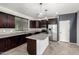 Well-equipped kitchen featuring dark wood cabinetry, stainless steel appliances, an island, and stylish pendant lights at 8879 W Cameron Dr, Peoria, AZ 85345