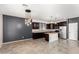 Modern kitchen featuring dark wood cabinets, stainless steel appliances, a stylish island, and tiled floors at 8879 W Cameron Dr, Peoria, AZ 85345