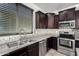 A kitchen with stainless steel appliances, dark wood cabinets, and a window at 8879 W Cameron Dr, Peoria, AZ 85345