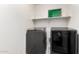 Modern laundry room features side-by-side washer and dryer with a shelf providing extra storage at 8879 W Cameron Dr, Peoria, AZ 85345