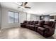 Spacious living room featuring tile floors, a modern ceiling fan, and a large leather sofa at 8879 W Cameron Dr, Peoria, AZ 85345