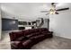 Open-concept living room with tile flooring, a ceiling fan, and a view into the kitchen and staircase at 8879 W Cameron Dr, Peoria, AZ 85345