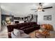 Open living area with a large leather sofa, ceiling fan, and view into the kitchen and dining area at 8879 W Cameron Dr, Peoria, AZ 85345