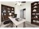 Well-lit office with built-in shelving, a spacious desk, ceiling fan and a comfortable workspace at 8879 W Cameron Dr, Peoria, AZ 85345