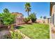 Picturesque backyard showcasing artificial turf, mature trees, and block fence at 8921 W Laurel Ln, Peoria, AZ 85345