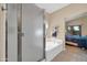 Bathroom featuring a soaking tub and tiled floor leading into the Primary bedroom at 8921 W Laurel Ln, Peoria, AZ 85345