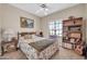 Cozy bedroom with ceiling fan, bookcase, and a tranquil view of a peaceful outdoors at 8921 W Laurel Ln, Peoria, AZ 85345