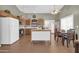 A kitchen area features a center island, wood cabinets, white appliances, and a dining table at 8921 W Laurel Ln, Peoria, AZ 85345