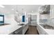 Open concept kitchen with stainless steel appliances, white cabinets, and eat-in island with sink at 9936 E Revolution Dr, Mesa, AZ 85212