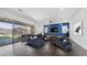Bright living room with a blue accent wall, sleek furniture, and sliding glass doors to the backyard at 9936 E Revolution Dr, Mesa, AZ 85212