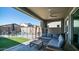 Inviting patio area with comfortable seating, overlooking a sparkling pool and well-manicured lawn at 9936 E Revolution Dr, Mesa, AZ 85212