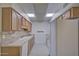 Well-lit kitchen features oak cabinetry, a dual basin sink, and modern appliances for a functional cooking space at 10020 W Royal Oak Rd # F, Sun City, AZ 85351