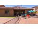 Backyard featuring a basketball hoop, a ping pong table and a patio with colorful chairs under an umbrella at 10402 E Starion Ave, Mesa, AZ 85212