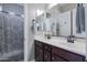 Bathroom with double vanity, a large mirror, dark wood cabinets, and a shower featuring a patterned curtain at 10402 E Starion Ave, Mesa, AZ 85212