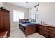 This bedroom features a wooden bed frame and matching dressers, along with decor for a sports fan at 10402 E Starion Ave, Mesa, AZ 85212