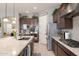 This kitchen has granite countertops, stainless steel appliances, and plenty of storage in dark wooden cabinets at 10402 E Starion Ave, Mesa, AZ 85212