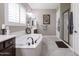 Elegant bathroom featuring a soaking tub, tiled floor, and a separate shower at 10402 E Starion Ave, Mesa, AZ 85212