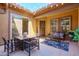 A cozy covered patio with a dining set, comfortable seating, decor, and string lights at 10402 E Starion Ave, Mesa, AZ 85212