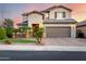 Charming two-story home with a well-manicured lawn and inviting curb appeal set against a colorful sunset sky at 11127 E Tripoli Ave, Mesa, AZ 85212