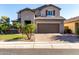 Inviting two-story home with a well-maintained lawn, spacious driveway, and classic architectural details at 11127 E Tripoli Ave, Mesa, AZ 85212