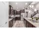 Modern kitchen featuring stainless steel appliances, granite countertops, a tiled backsplash, and custom dark wood cabinets at 11127 E Tripoli Ave, Mesa, AZ 85212