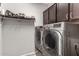 Laundry room with stainless steel washer and dryer, upper cabinet storage, and convenient shoe rack at 11127 E Tripoli Ave, Mesa, AZ 85212