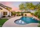 Beautiful backyard pool area with a waterfall feature, lush landscaping, and a covered patio for relaxation and entertainment at 11127 E Tripoli Ave, Mesa, AZ 85212