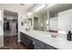 Bright bathroom featuring dual sinks, a large mirror, gray cabinets, and a walk-in closet at 11473 W Austin Thomas Dr, Surprise, AZ 85378